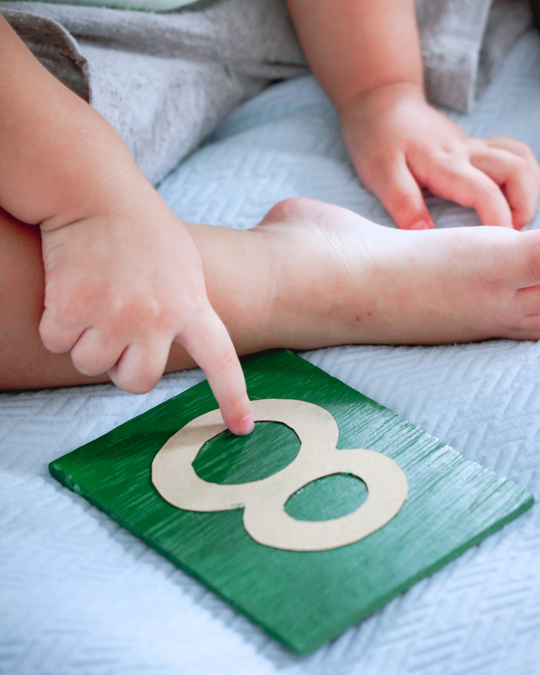 Ein kleines Kind deutet mit dem Finger auf Montessori-Lernmaterial